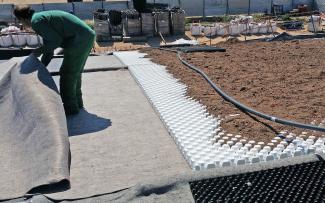 In the pitched roof area up to 25°, the substrate interlocks with the Floraset® FS 75 elements, while in the flat area of the roof ridge (in the foreground) Floradrain® FD 40-E is used. Substrate, Floraset® FS 75 elements and Floradrain® FD 40-E on a pitched roof